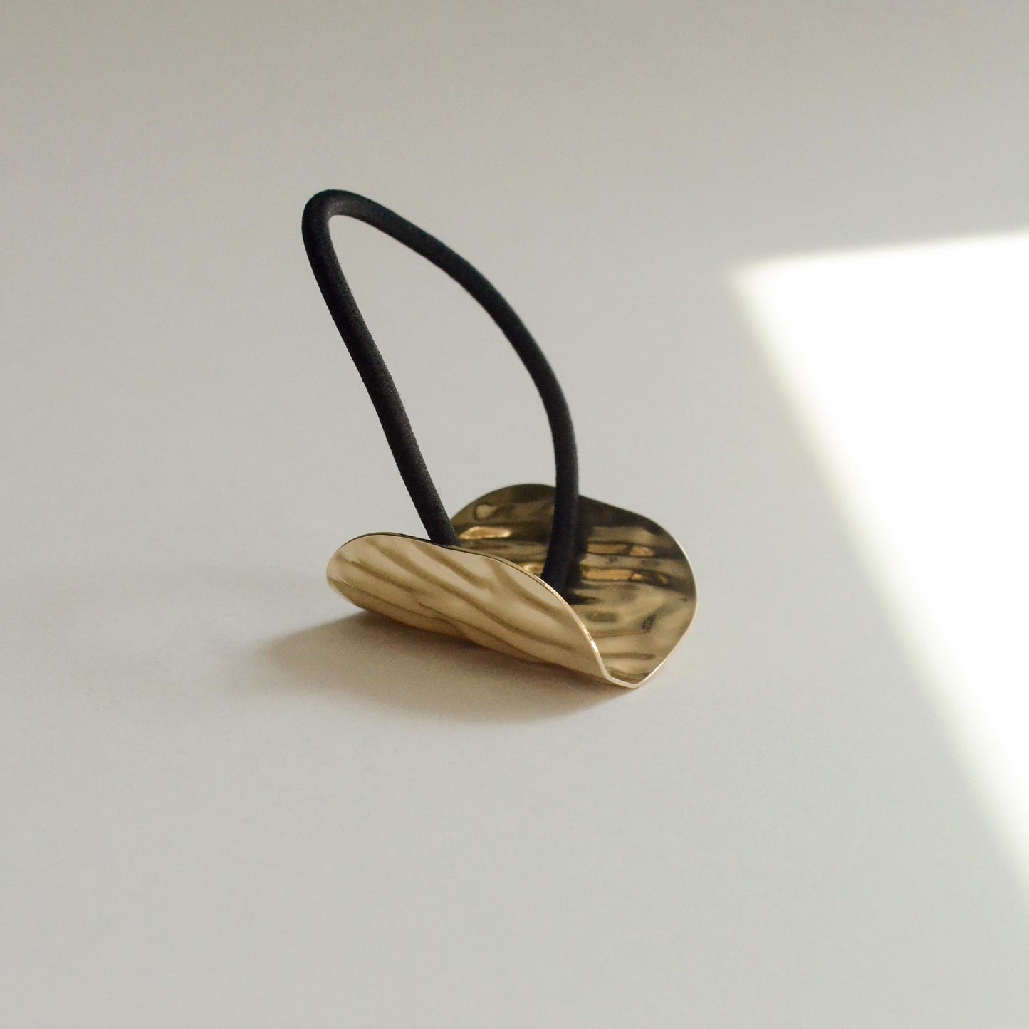 Hair tie with gold textured surface