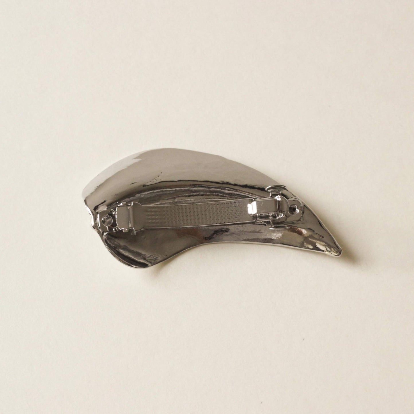 back side of silver barrette hair clip with a shape of leaf