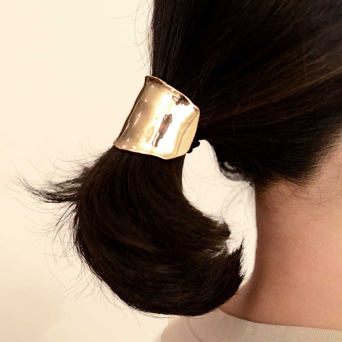 a lady wearing a metal gold hair cuff holder