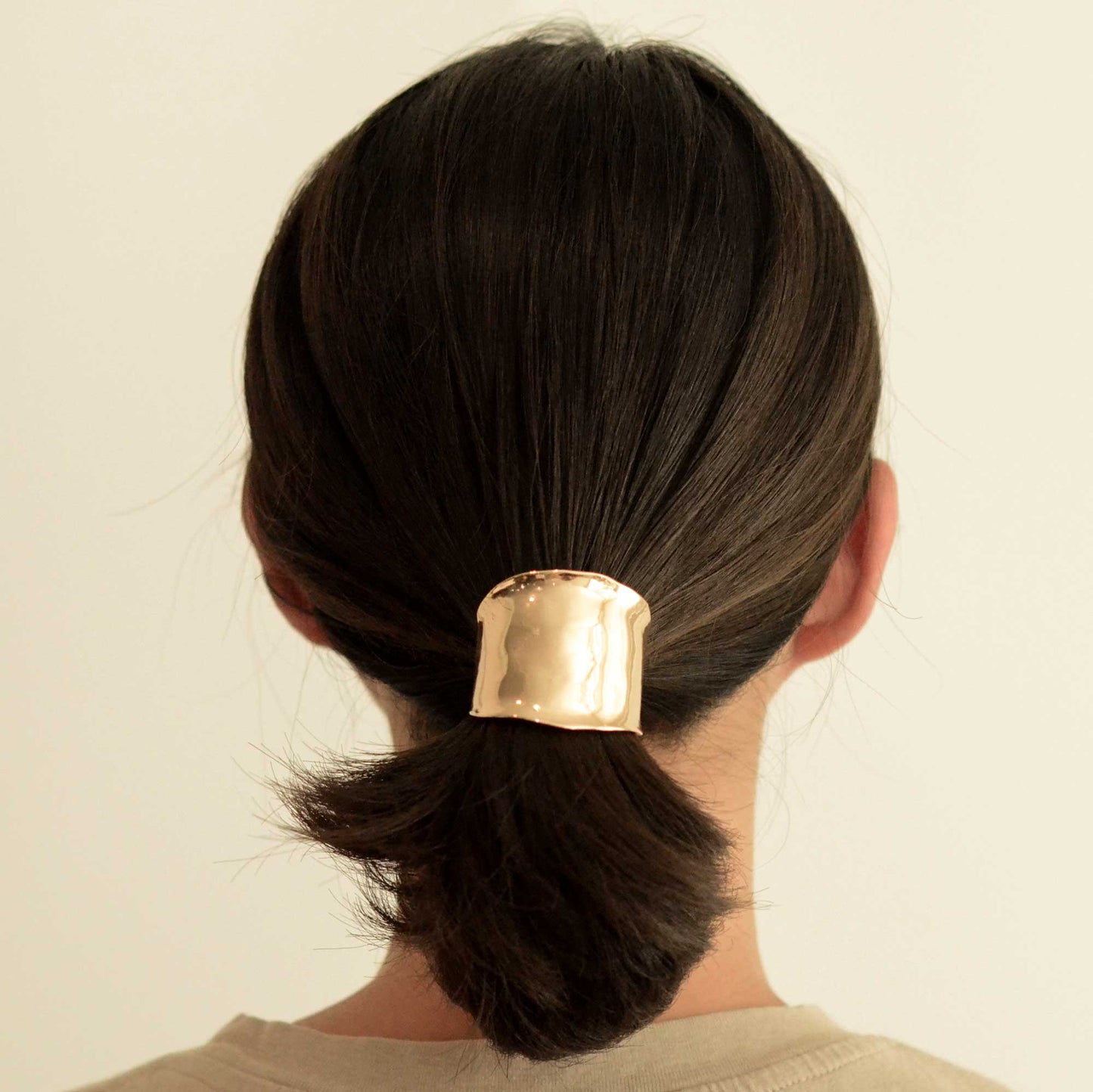 a lady with a metal gold hair cuff holder