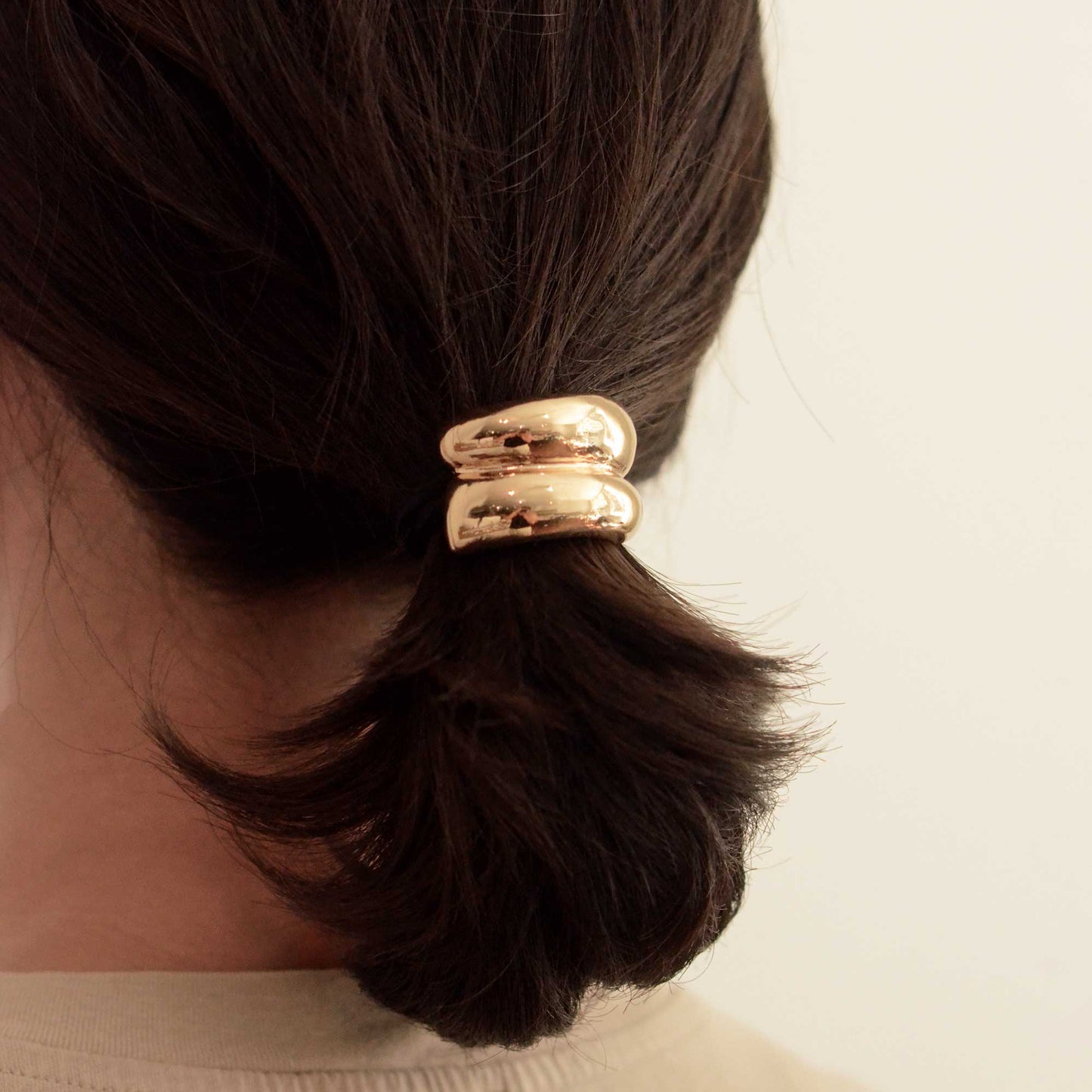 a lady wearing a mini gold hair cuff tie