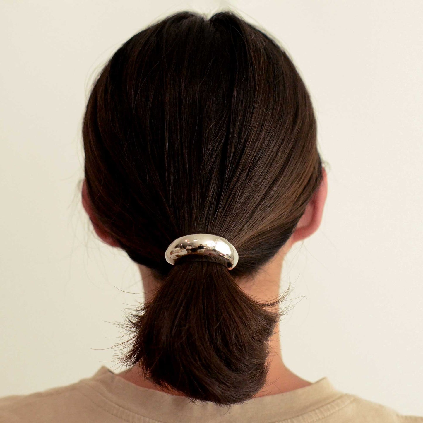 a lady wearing a narrow sized hair cuff tie colored silver
