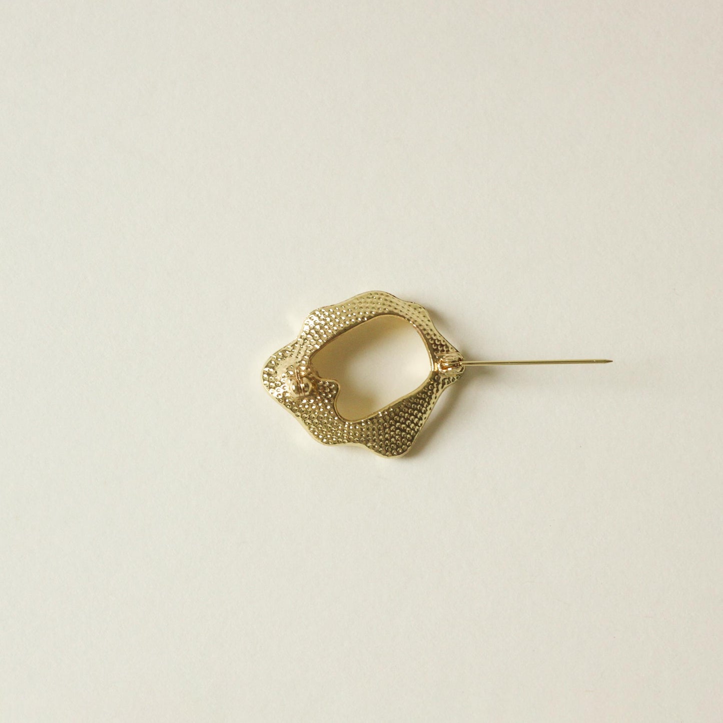 back side of metal brooch with ripple shape