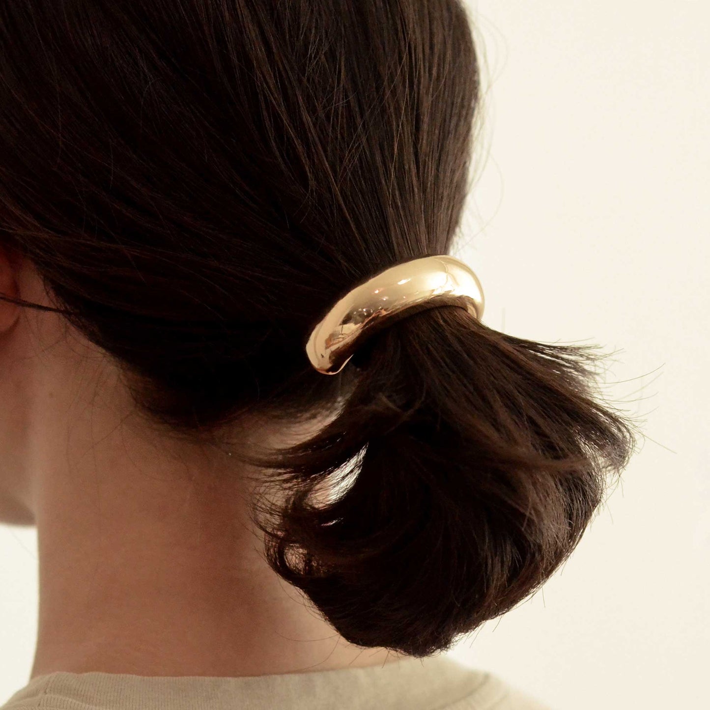 side view of the lady wearing a gold cuff hair tie