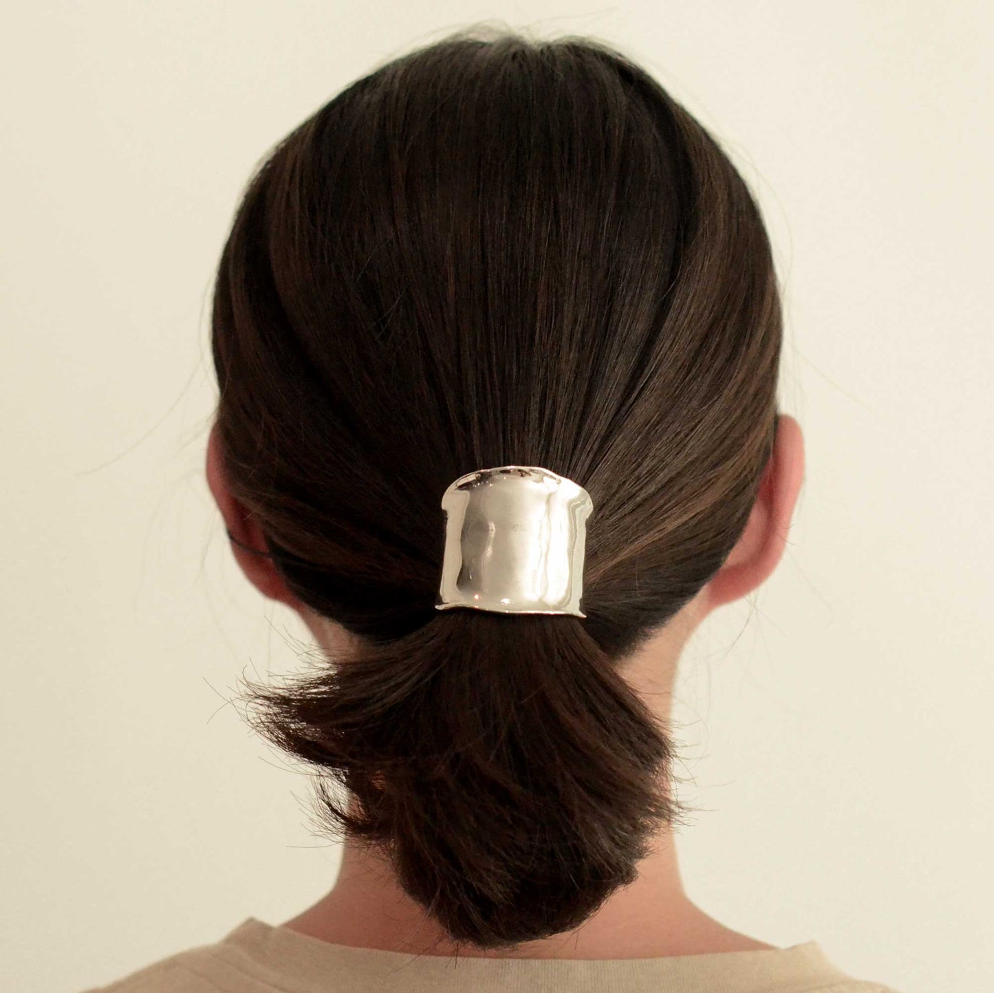 a lady wearing a silver metal hair cuff holder
