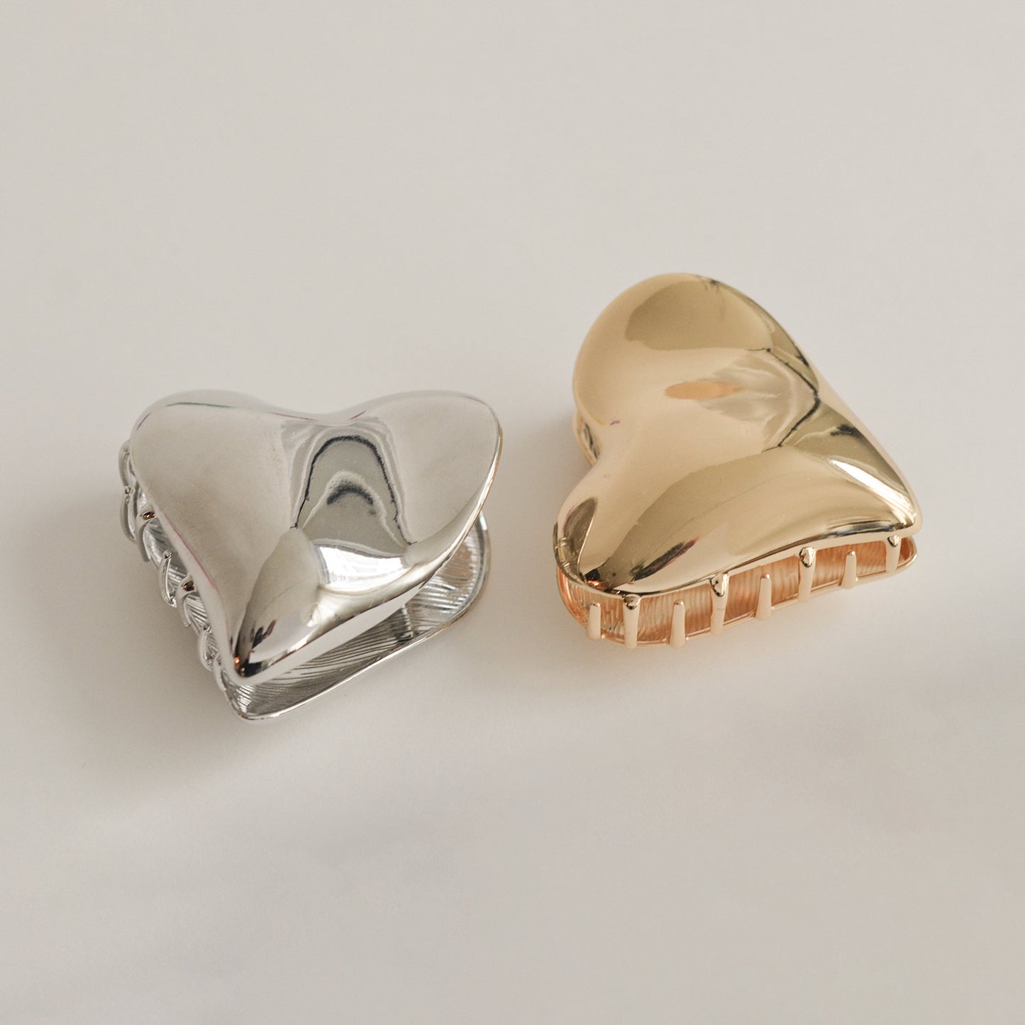 two colors of heart-shaped hair claw clips: silver and gold