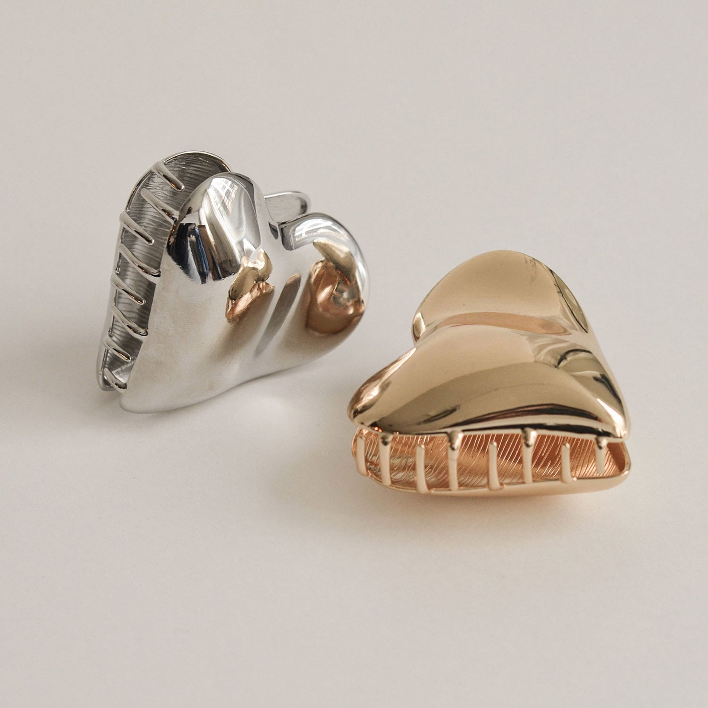 A silver and gold hair claw clip shaped like a heart