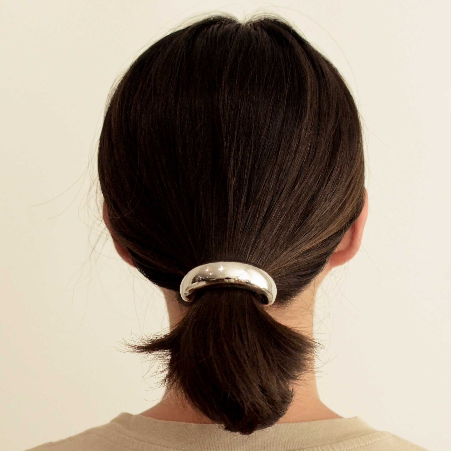 a lady wearing wide silver hair cuff tie