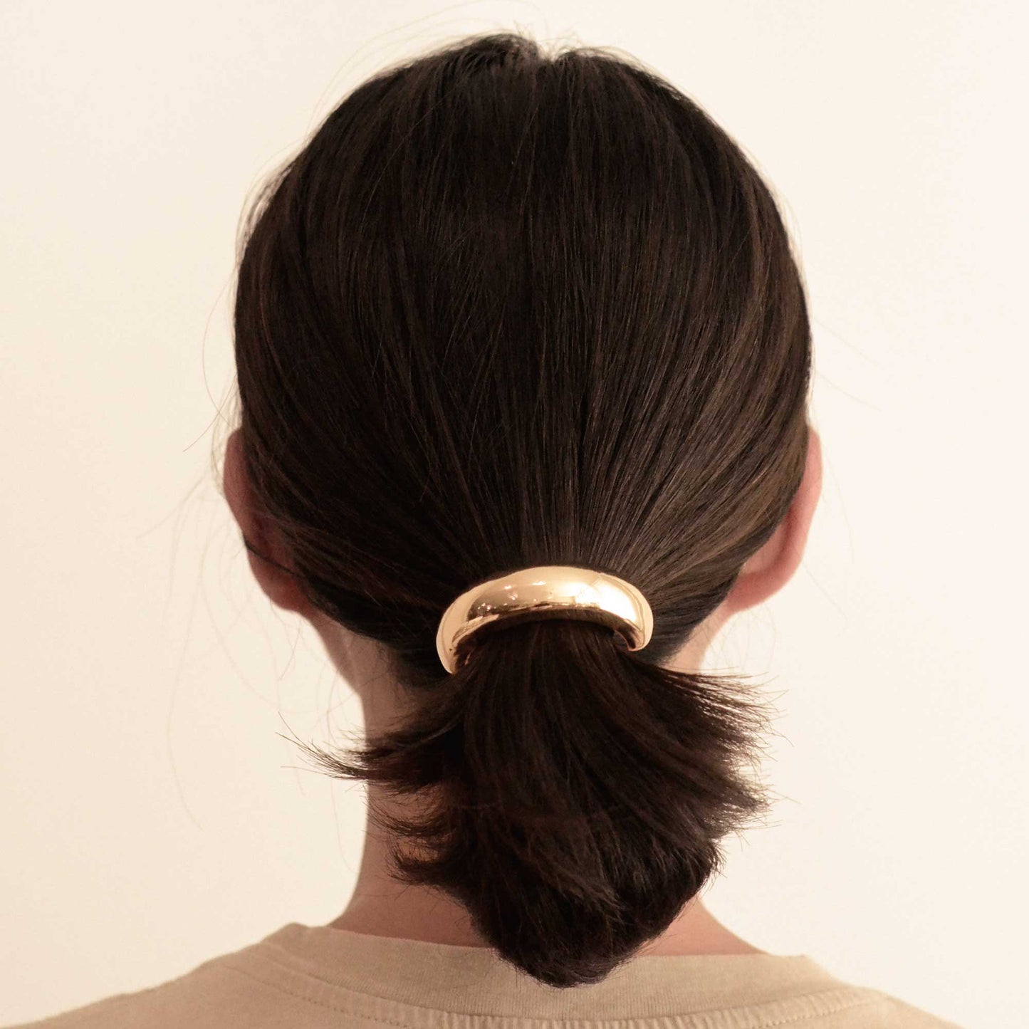 a lady wearing a wider gold hair cuff tie