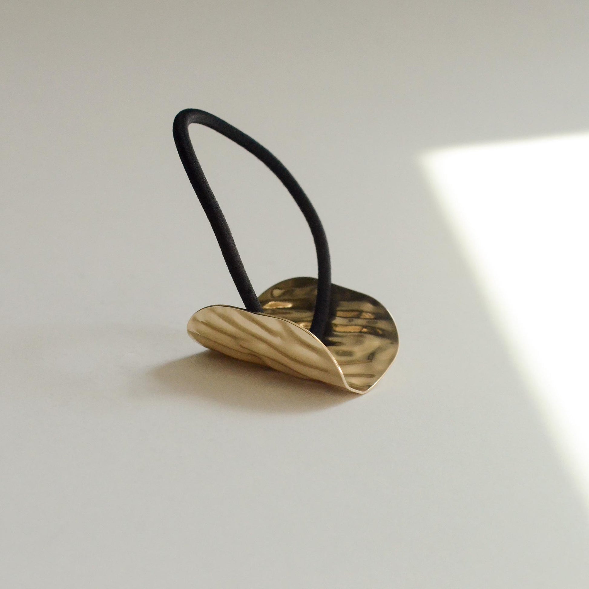 Hair tie with gold textured surface