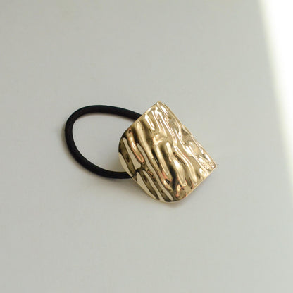 Metal hair tie with textured gold finish