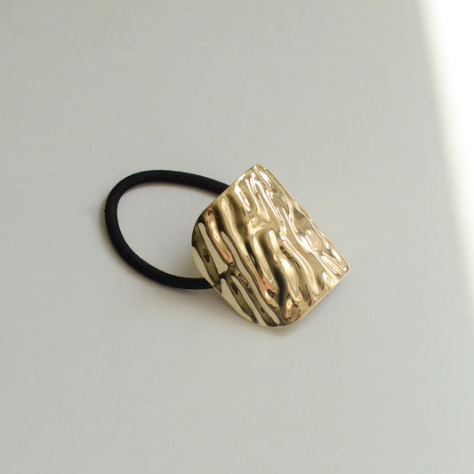 Metal hair tie with textured gold finish
