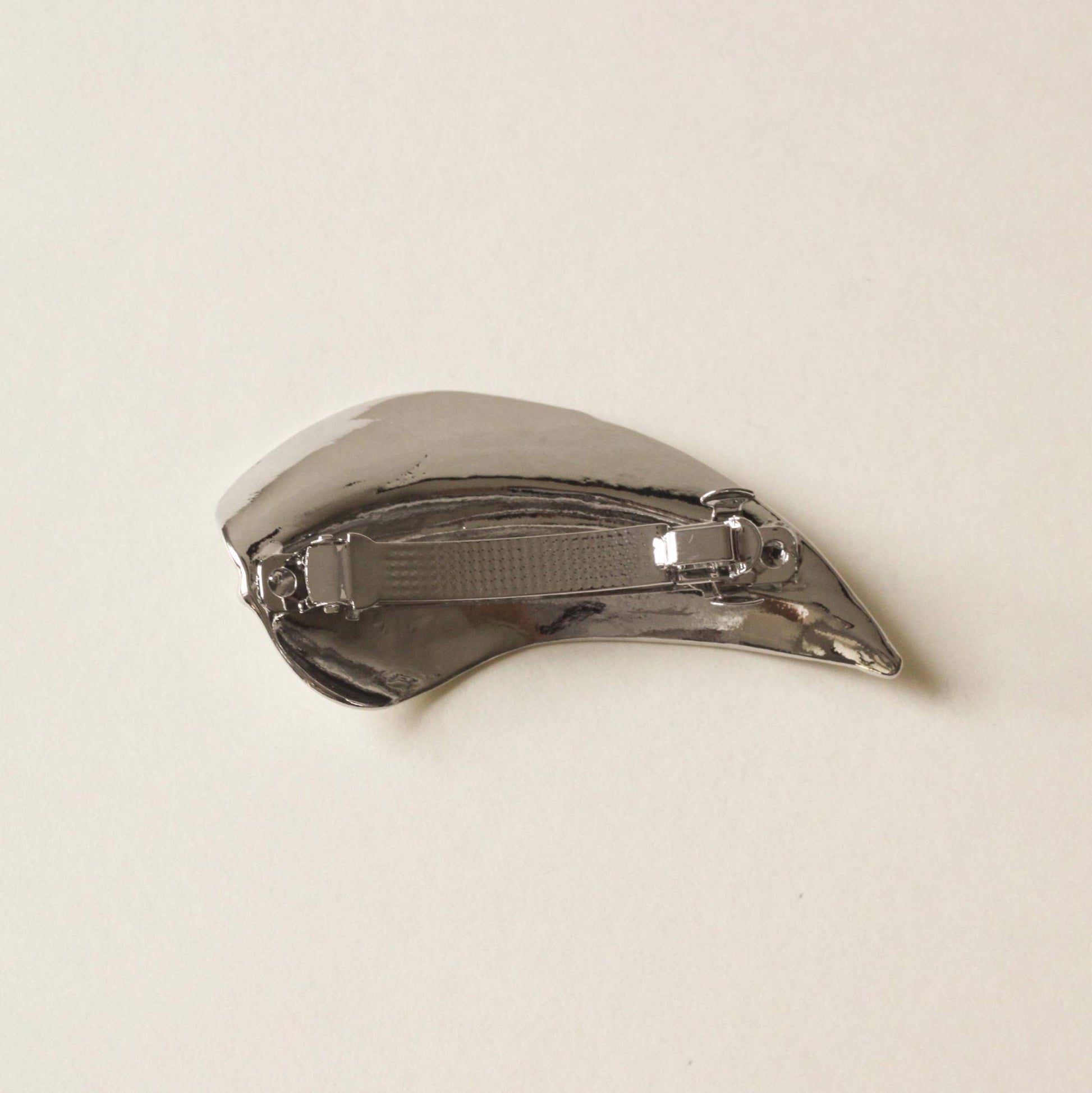 back side of silver barrette hair clip with a shape of leaf