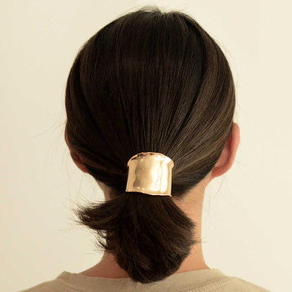 a lady with a metal gold hair cuff holder
