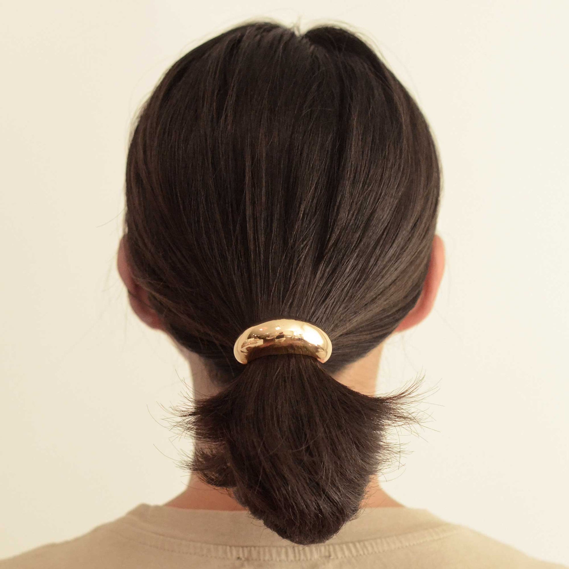 a lady with gold narrow cuff hair tie
