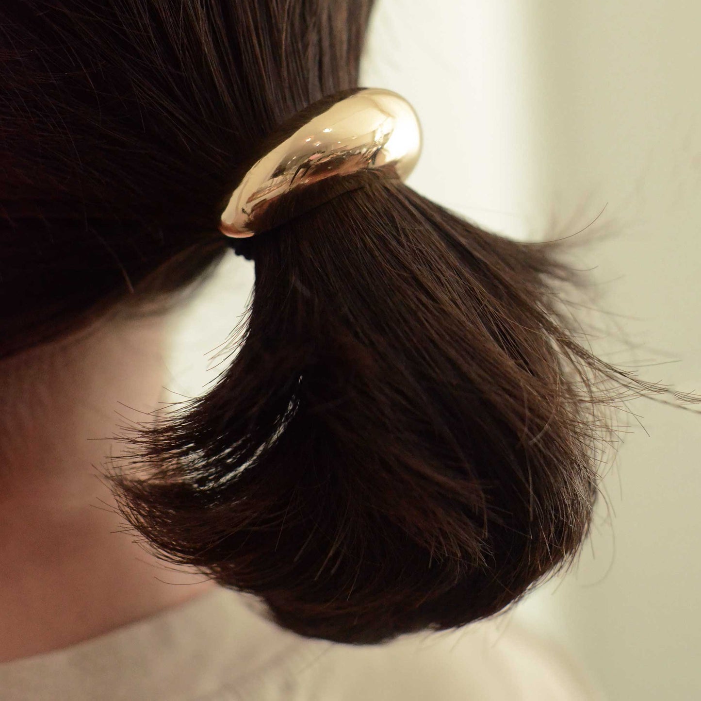 a lady wearing a narrow sized gold cuff hair tie