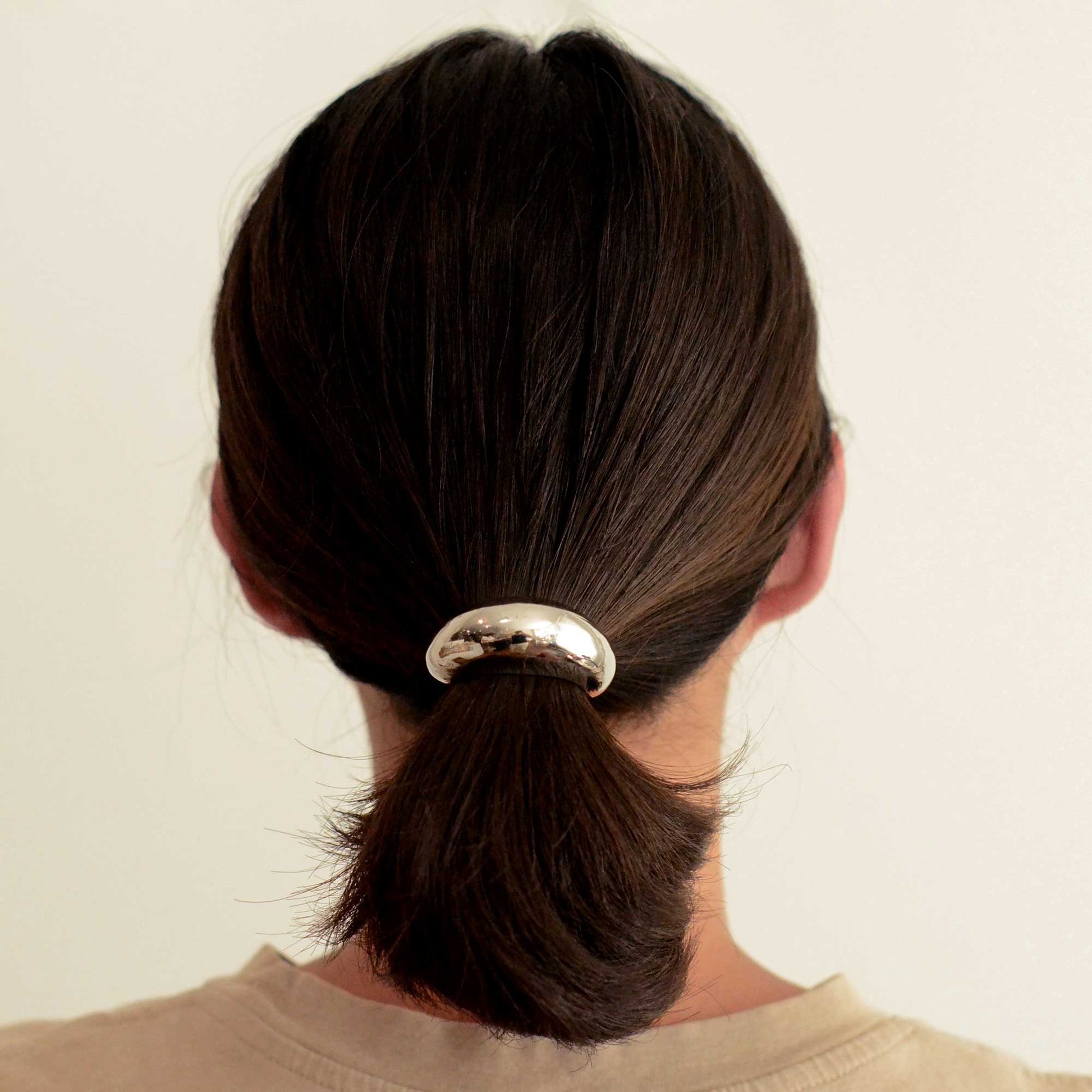 a lady wearing a narrow sized hair cuff tie colored silver