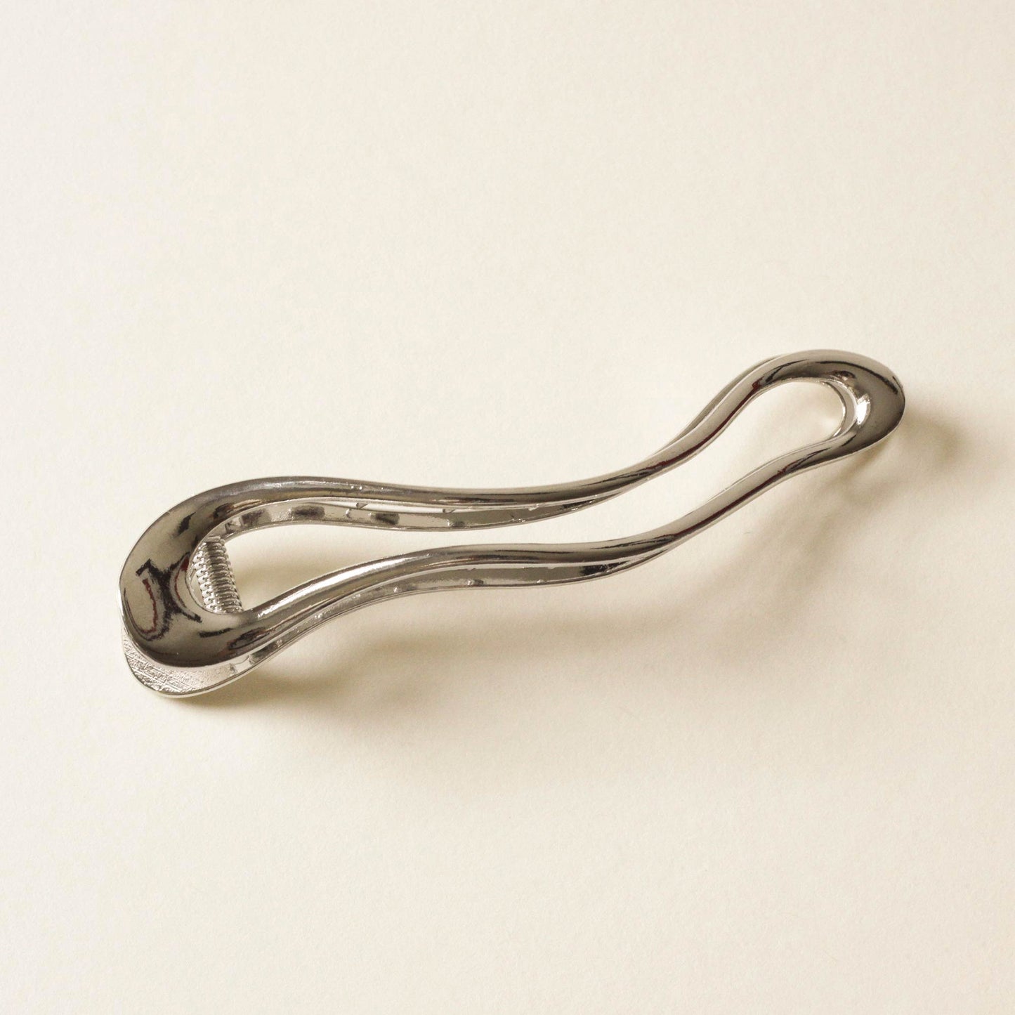 polished silver hair claw clip with an organic shape