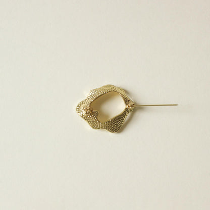 back side of metal brooch with ripple shape